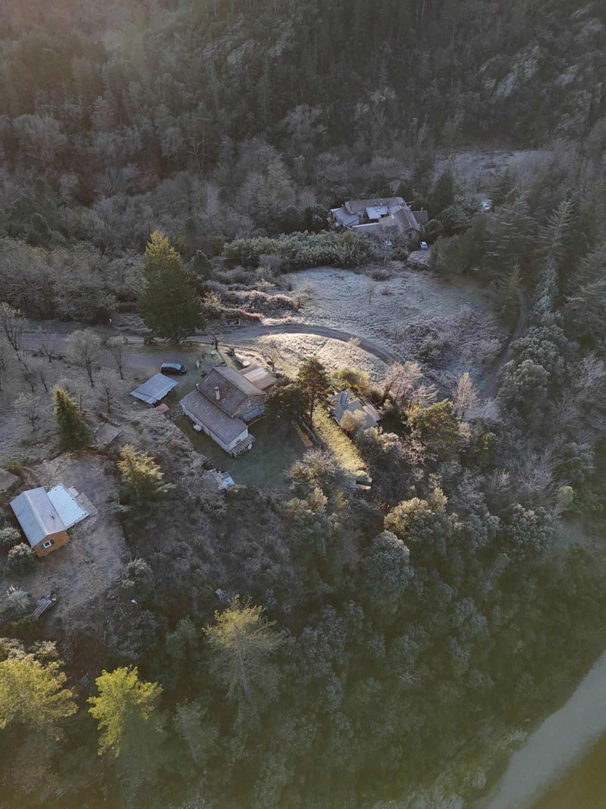 Vue aérienne du Moulin du Pistou : les bâtiments du domaine entourés de forêt, avec la Cèze en bas à droite